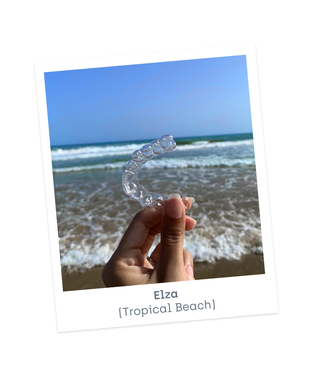 Photo holding invisible aligners at the beach