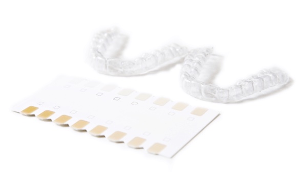 Clear retainers with tooth shade guide showing whitening results